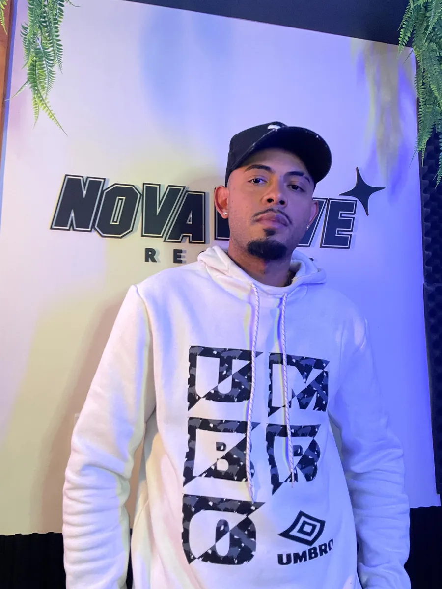 Dom' Julio, artista que gravou na Nova Wave Records, em frente ao painel do estúdio